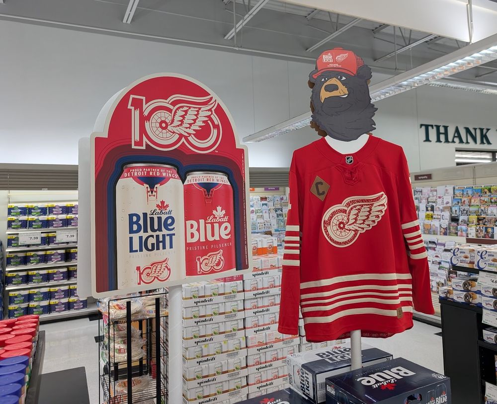Display in a grocery store. It's a Labatt Blue Light setup, with a carboard bear, wearing a Detroit Red Wings Dylan Larkin jersey.