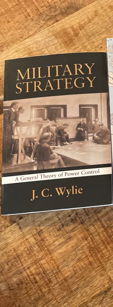 Military strategy, by JC Wylie. A general theory of power control. 

Front cover is black with a black and white photo of sailors and naval officers at a map board doing a wargame. 