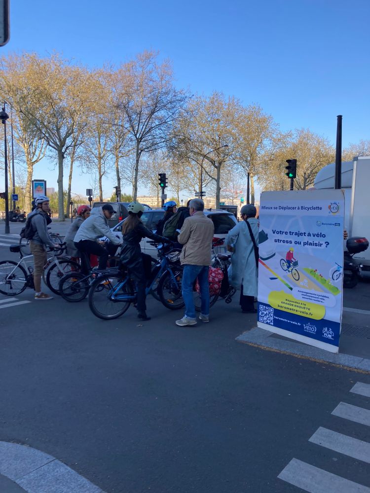 Facile d'échanger avec les cyclistes au coeur de Paris : à chaque feu rouge, des dizaines de personnes arrêtées prennent le temps d'échanger ! Le sujet est rapidement identifié grâce à notre affiche géante.