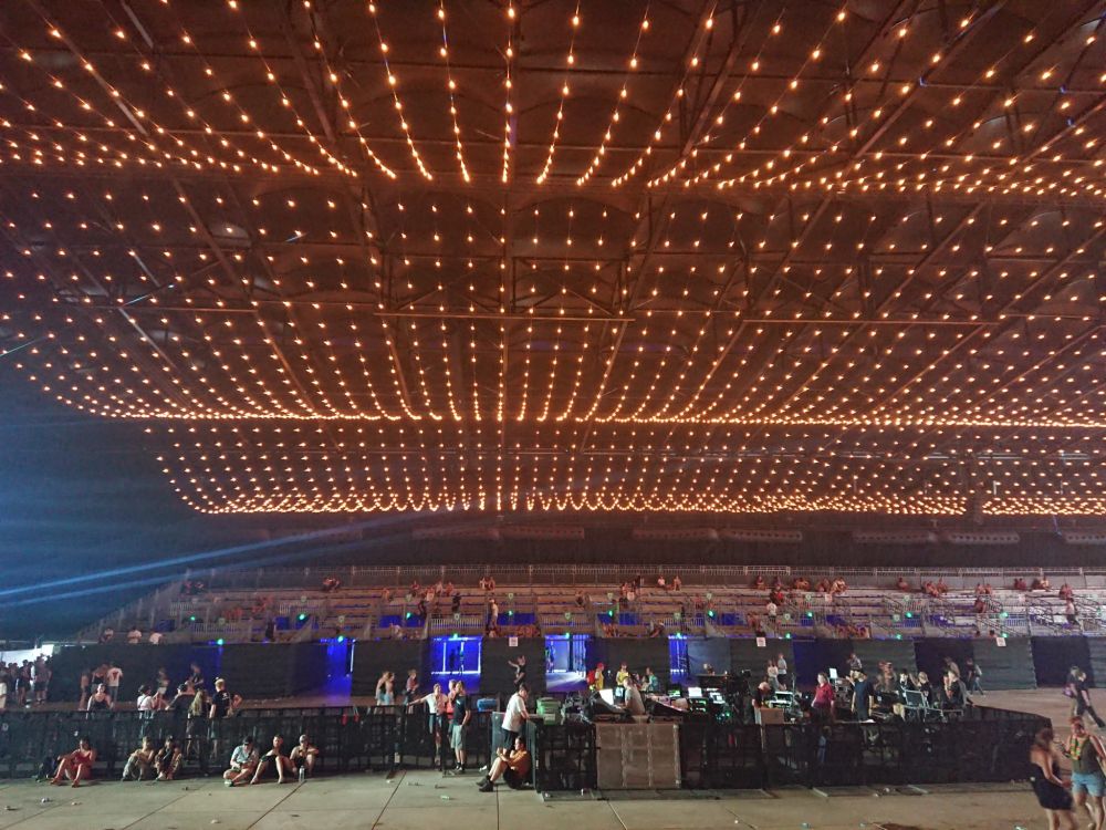 Erormous festival tent with strings of lights hanging on the ceiling.