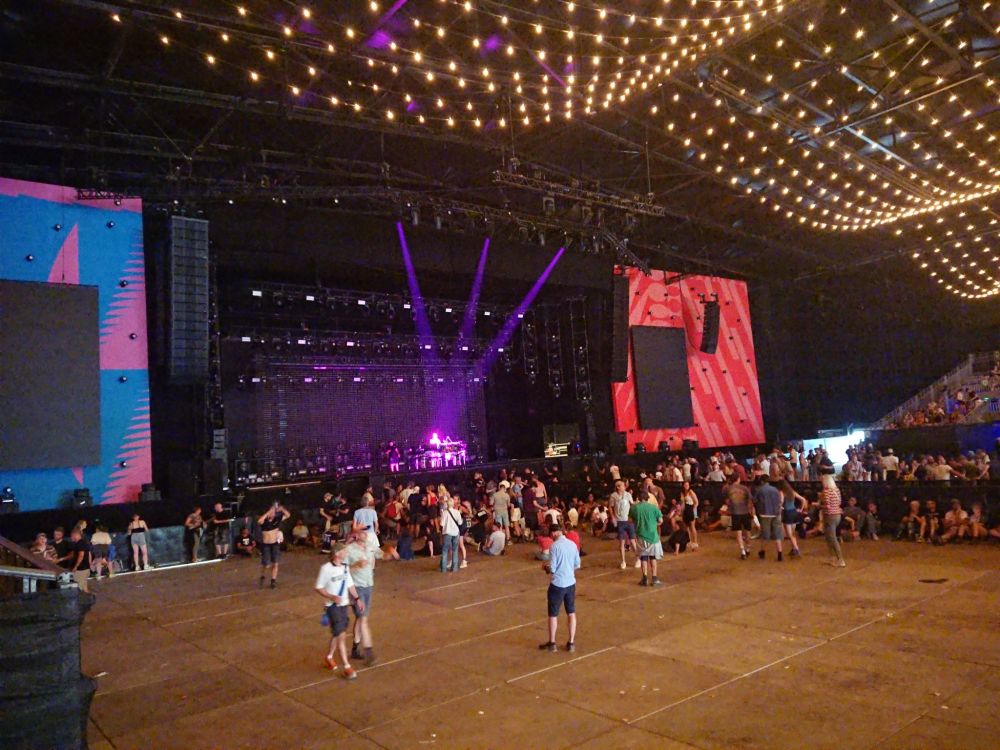 Big stage before the show  in enormous festival tent that is still quite pty. There are big screens to each side.