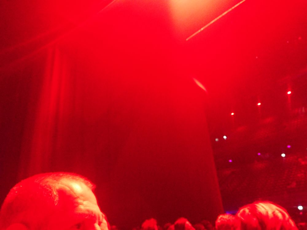 Bad photo of a stage that has curtains, bathing in red light.