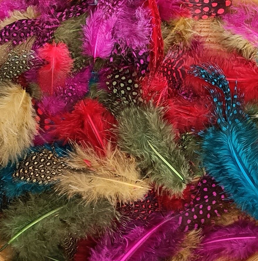 Artificial feathers with different colours, sizes and shapes: yellow, red, pink, green and turquoise. Some have sort of a dotted pattern. Bright, beautiful colours.
