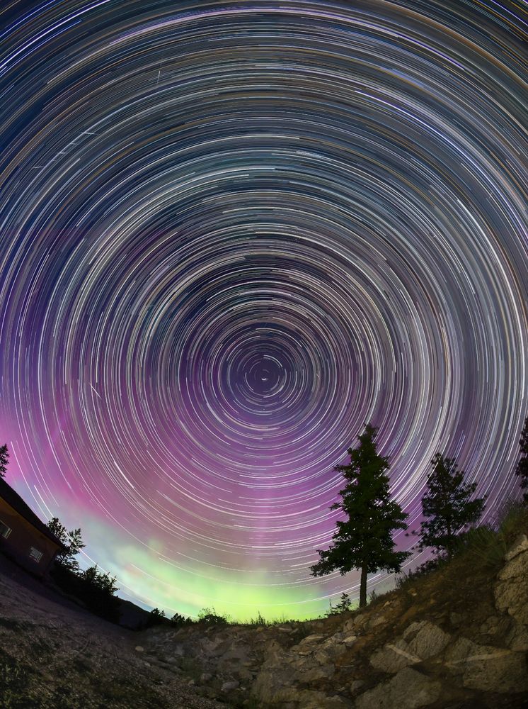 star trails around the North star shows the Earth's rotation in four hours of exposures. A faint aurora with pink and green completed the scene.