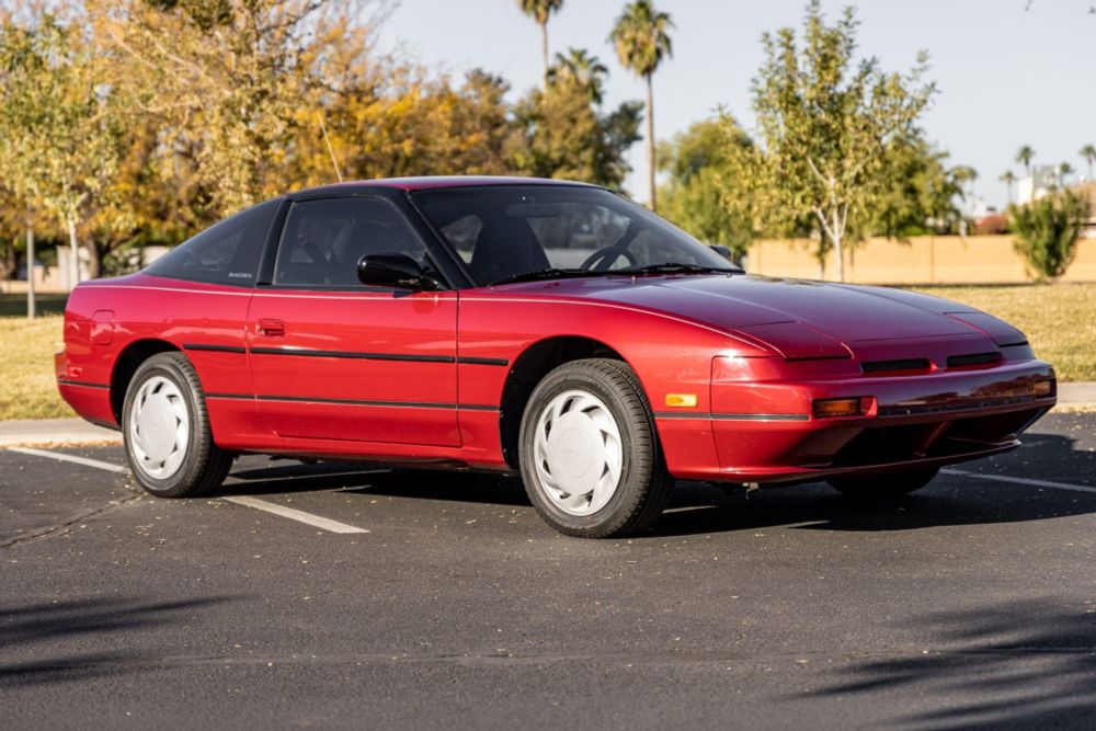 Burgundy S13 Nissan 240SX hatchback in a parking lot