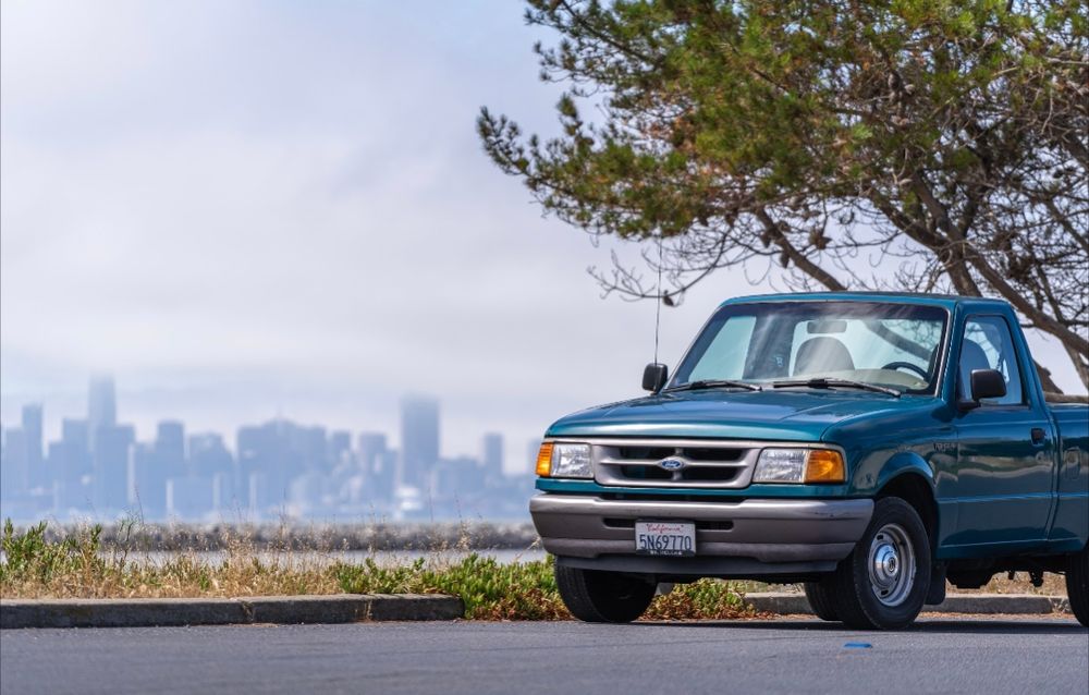 Teal 1997 Ford Ranger with San Francisco skyline in background 