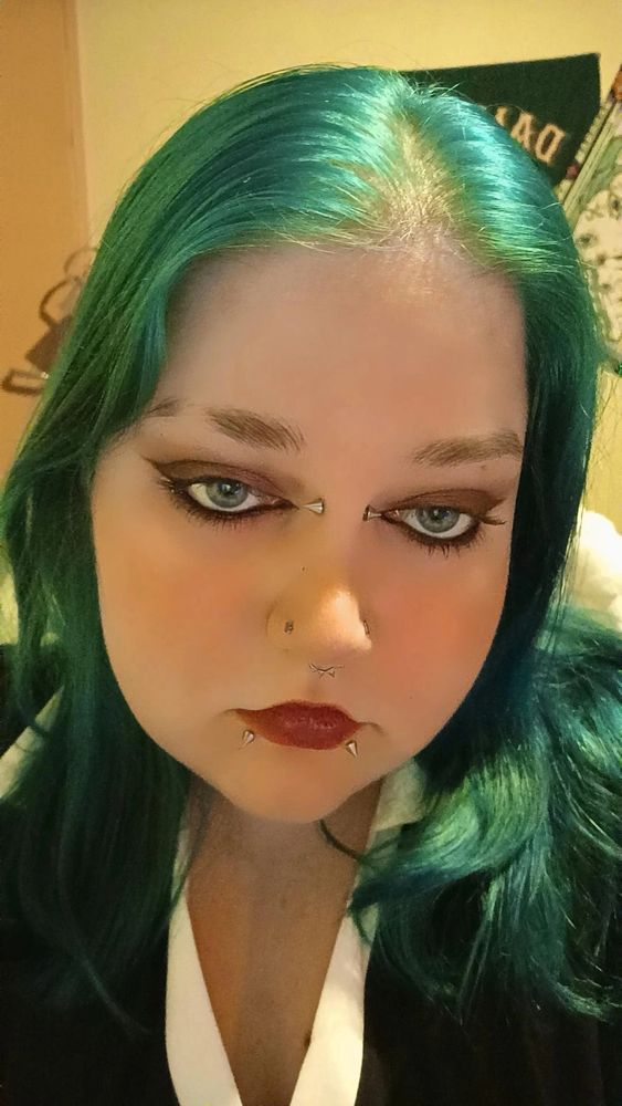 Moi cheveux bleus, make-up marron et noir en liner. Levres rouges. Tee-shirt noir et blanc au niveau du col