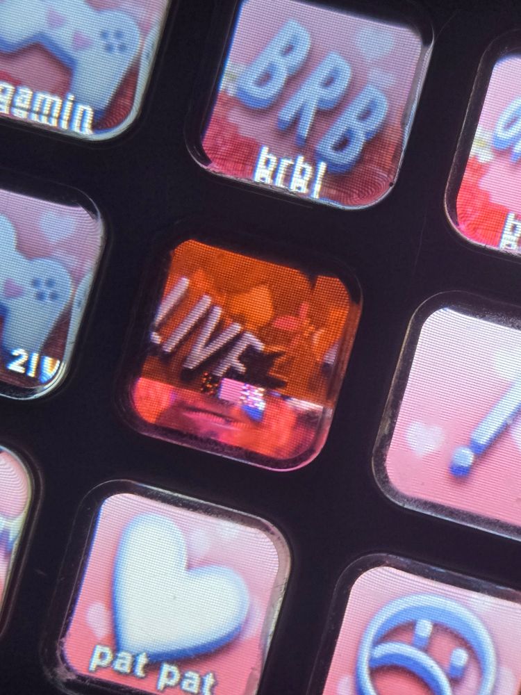 A close up of an elgato stream deck of a red button that says "LIVE." The screen of the button appears damaged, with the image appearing off-center and split apart