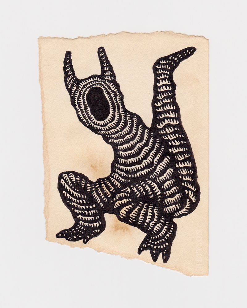 A scrap paper stained with coffee that has a drawing of a bipedal creature. It has a blank hole for a face, horns and a thick tail. The creature is constructed from a rope or tube-like material.