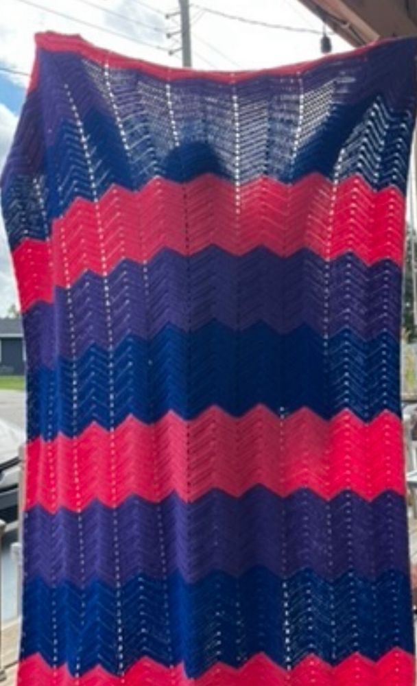 Large crochet chevron blanket with alternating stripes in blue, purple and pink (the bisexual pride flag colours)