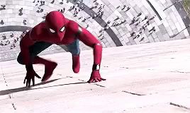 spider-man is crawling on the ground in front of a crowd .