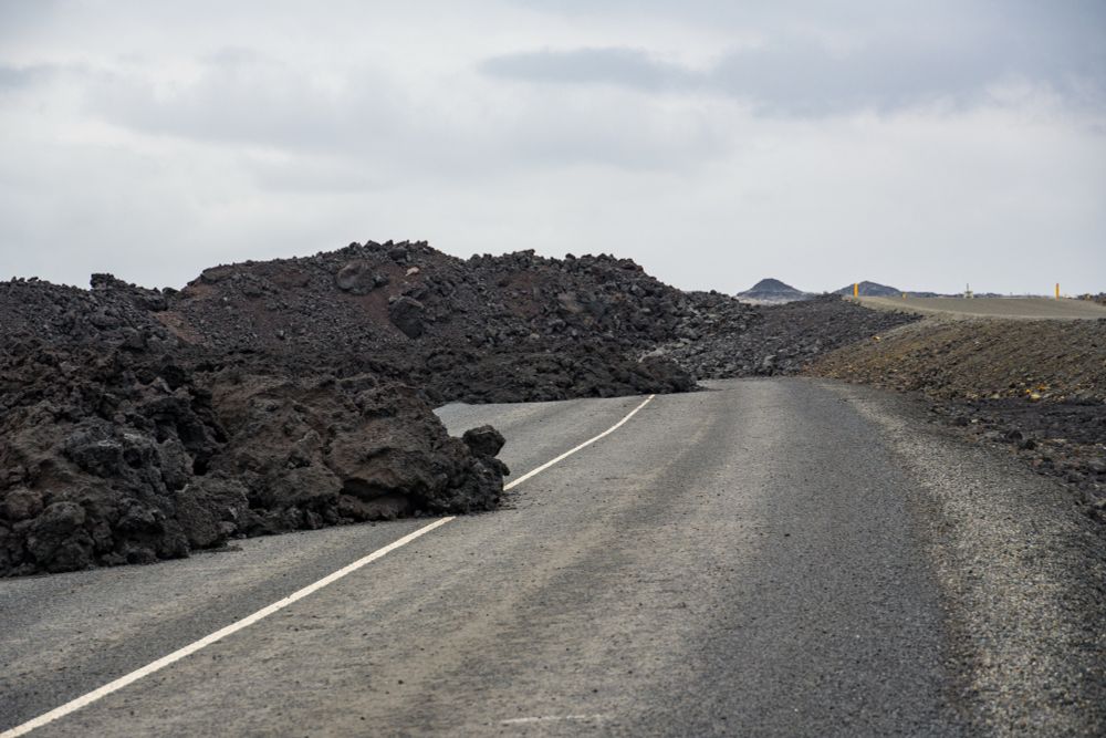 Tongues of crumbly lava reaching across a destroyed road near the Blue Lagoon. 