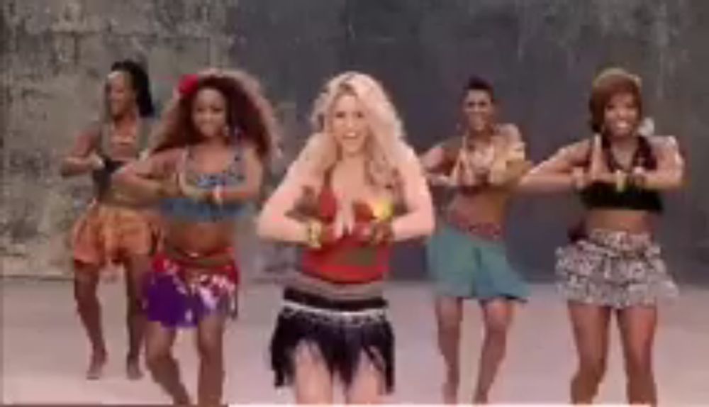 a group of women are dancing in a line with one woman wearing a red top