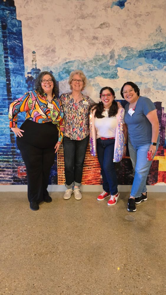 4 women standing in front of a mural. Images of the people tagged in the post. 