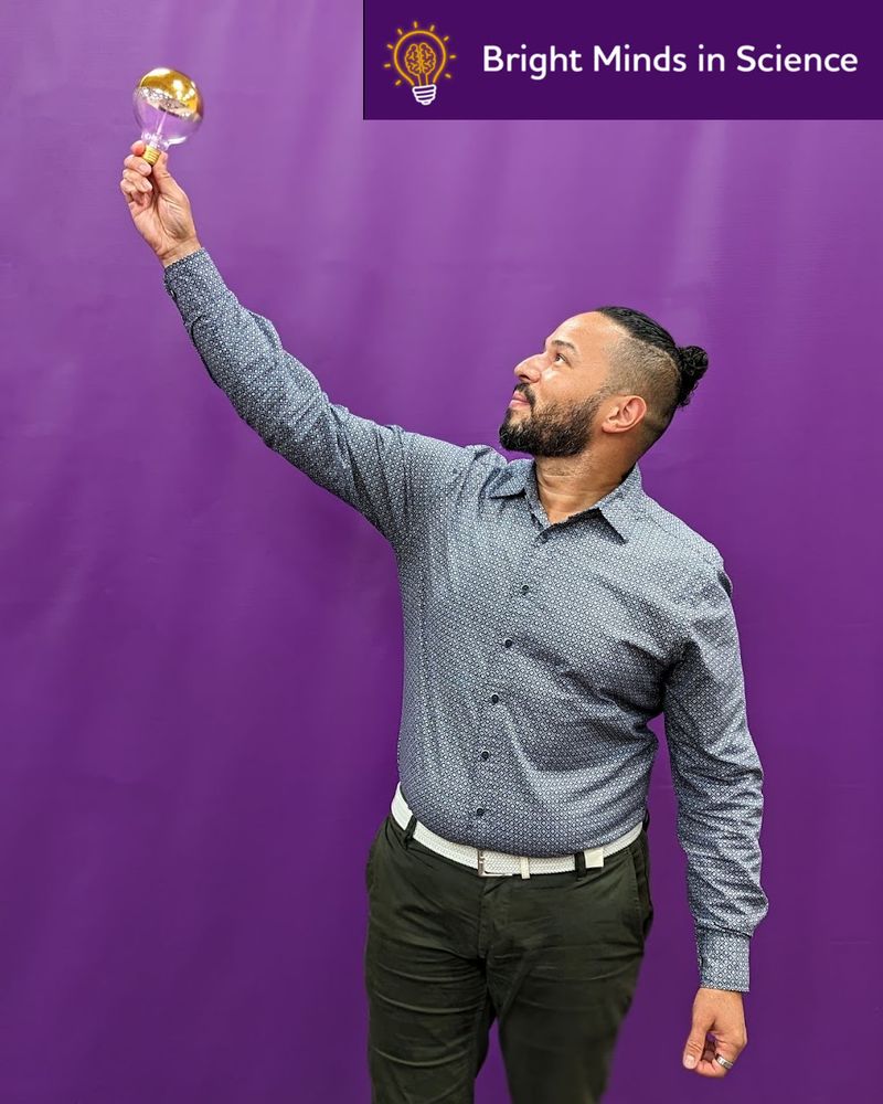 Luis Medina, Ph.D. looks at a lightbulb as he holds it aloft. Above his head, the words 'Bright Minds in Science' are next to a stylized lightbulb logo with a brain inside.
