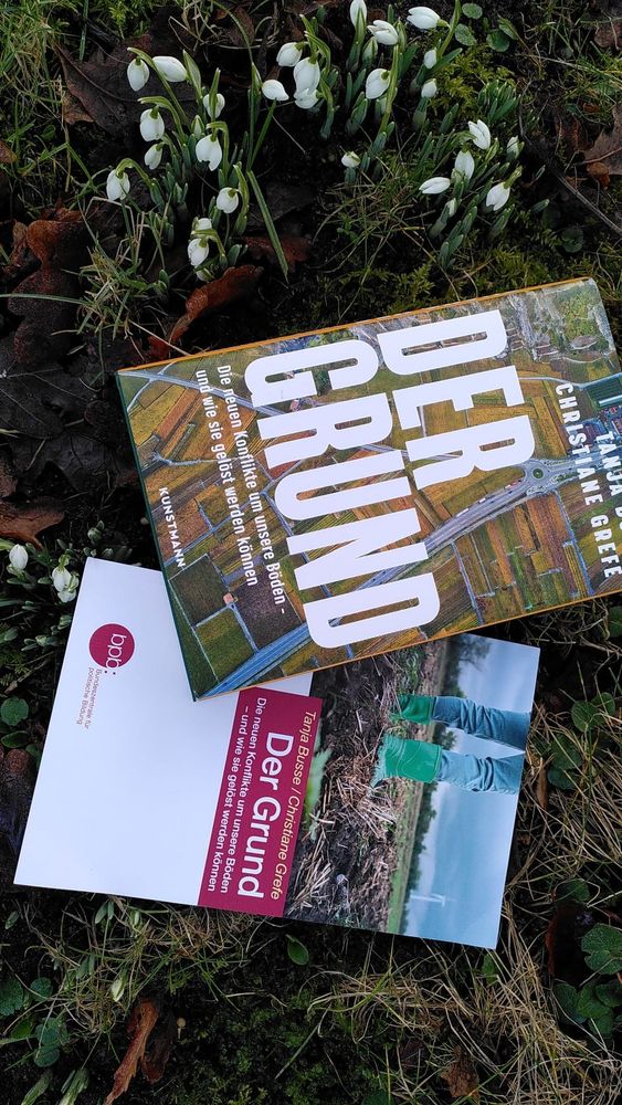 2 Bücher liegen im Gras  "Der Grund" im Kunstmann Verlag und von der Bundeszentrale polit. Bildung
