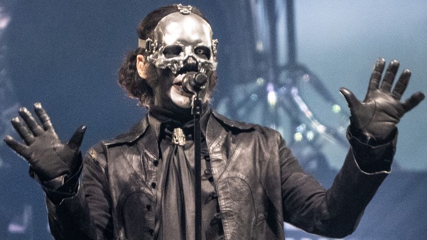 a shot of ghost's papa v perpetua, a man dressed in a black leather coat, gloves, I... think maybe a silk shirt and tie? and silver skull half mask