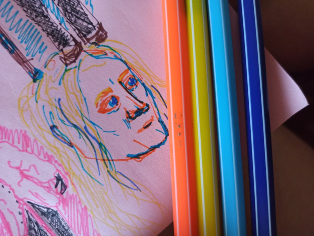 рисунок человеческой головы, светлокожего мужчины с жёлтыми волосами, выполненный четырьмя цветами: оранжевым, жёлтым, голубым и синим. Ручки этих цветов лежат рядом, в том же порядке, что и полоски на аро-эйс флаге.