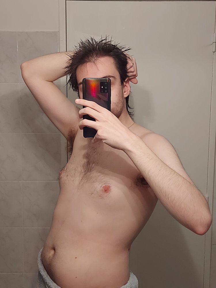 Moi torse nu, une serviette autour de la taille, le téléphone cachant mon visage