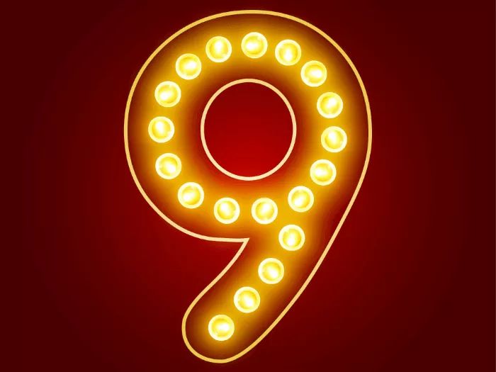 A decorative number "9" illuminated with bright yellow lights against a red background.