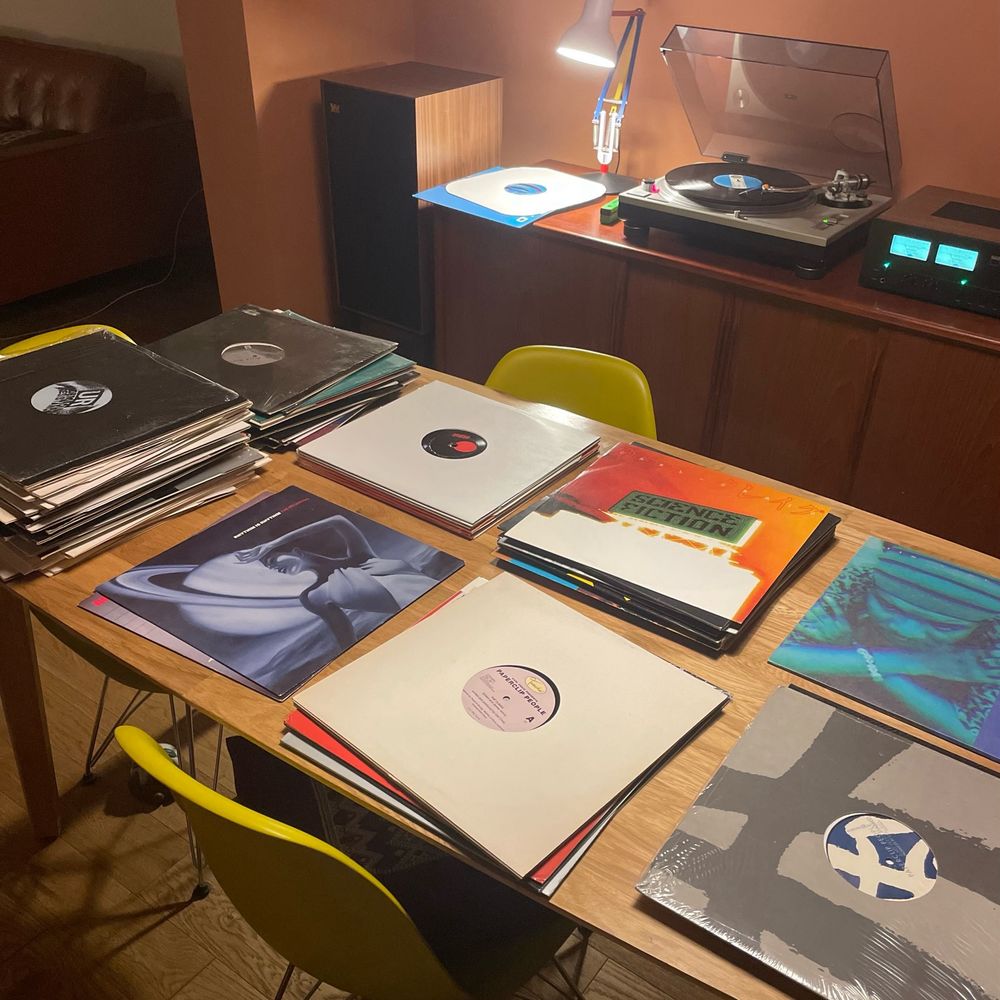 Table with piles of vinyl records on it