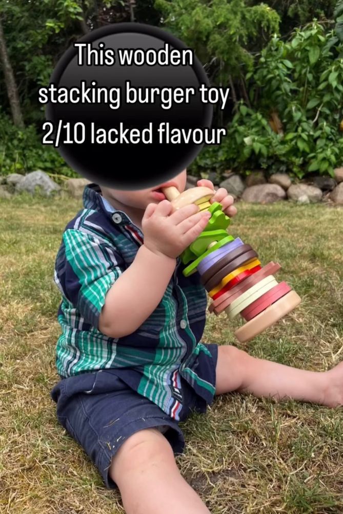 Baby eating wooden burger toy