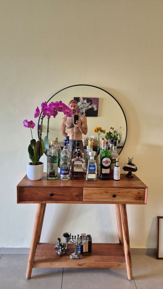A new picture of the console, bar and mirror with an orchid i was gifted and I am shirtless in the mirror