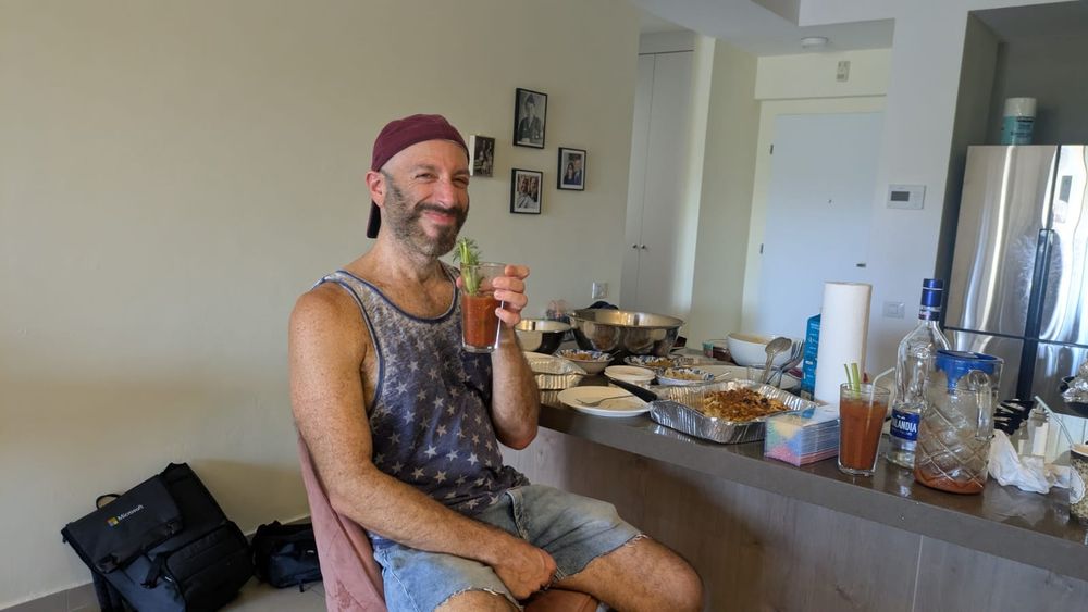Grinning after 2.5 bloodies wearing cutoff jeans, blue amd white star tank from Target, red Philadelphia Phillies hat