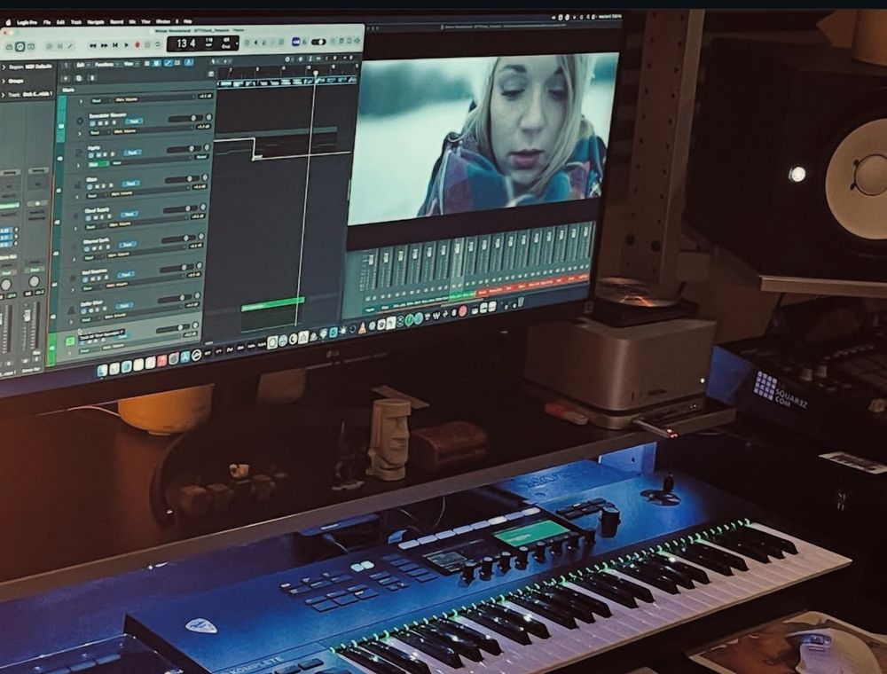 Desk with studio monitors, computer monitor, keyboard.