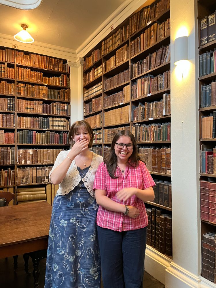 Two people laughing in a historic library
