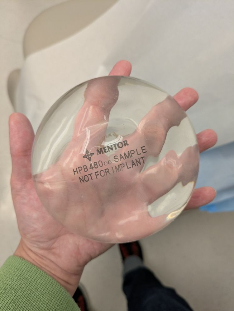 I am holding a clear breast implant about five inches in diameter. 