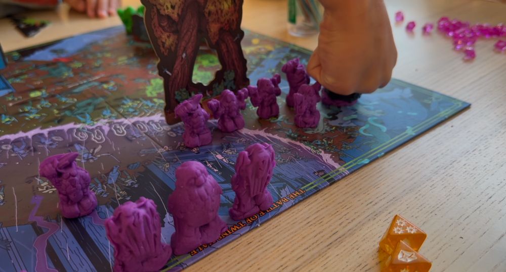 Board game of clay figures. One being smashed by a ringed fist. 