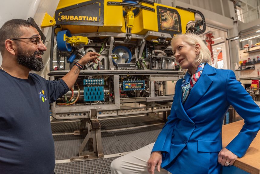 Wendy Schmidt speaks with an engineer in the foreground. In the background is underwater robot SuBastian. 