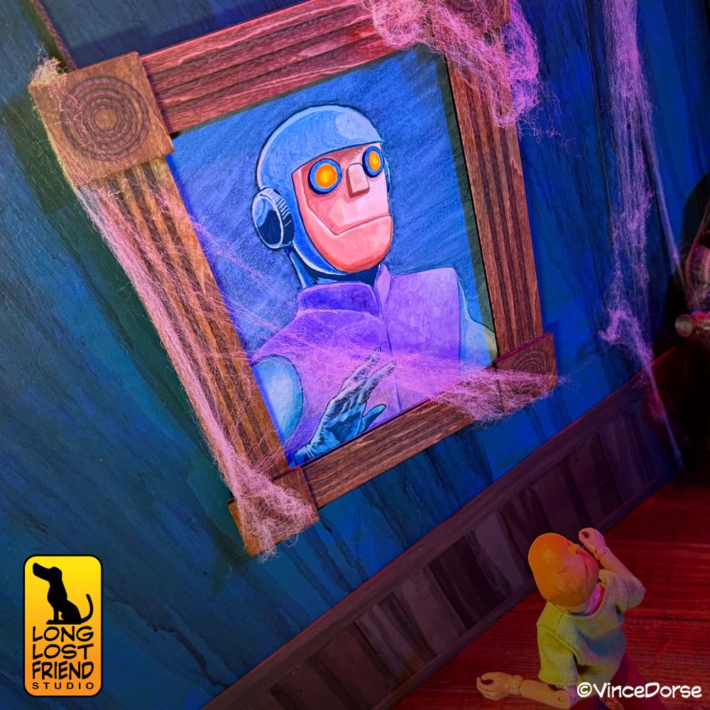 final portrait of Charlie the Robot from Scooby Doo, framed, and hanging in a diorama of a haunted gallery, festooned with cobwebs, while an action figure of Shaggy looks at the painting.
