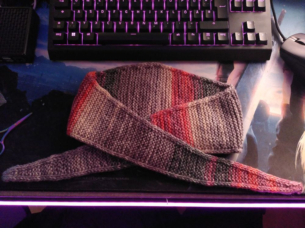 ein schmaler Schal mit einem Verlaufsgarn in den Farben Rot und Grau gestrickt.