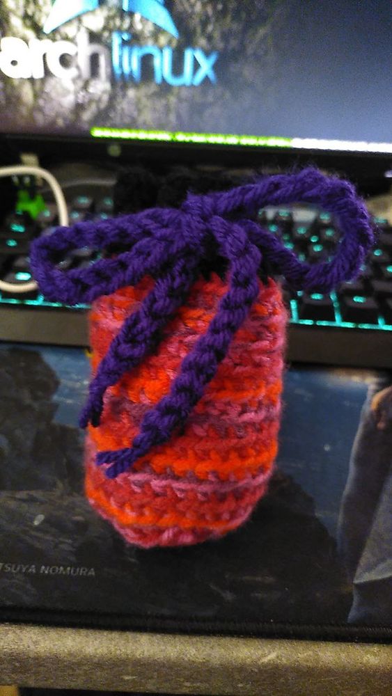 Eine Geschenkverpackung in den Farben rot, violett und Pink mit einer Schleife in Violett.