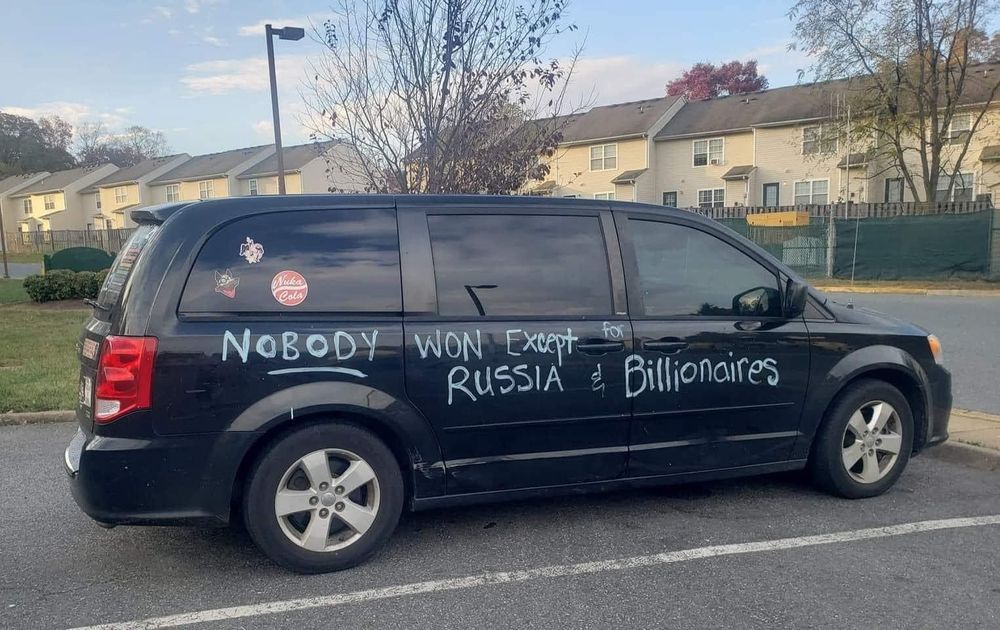 Van has writing on it that says: Nobody won except Russia and the Billionaires. 