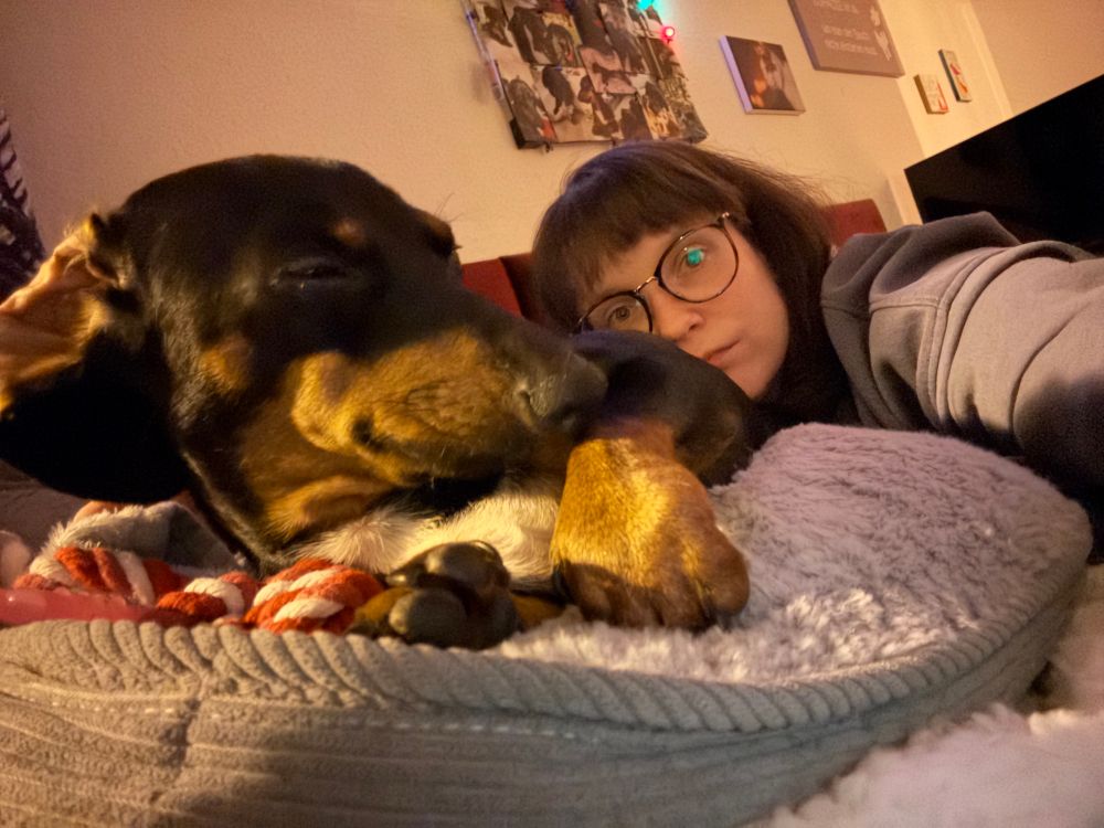 Selfie von mir und einem schwarz braunen Dackel. Dieses Mal hat der Dackel die Augen zu.