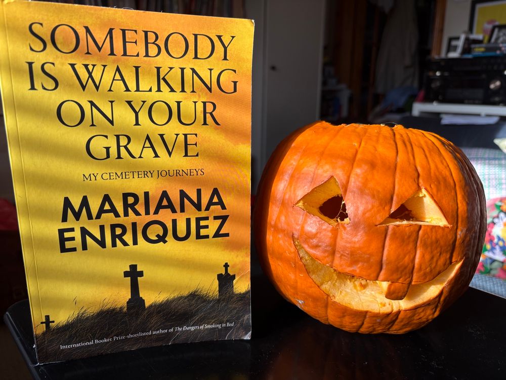 Mariana Enriquez’s ‘Somebody Is Walking On Your Grave’ next to a gap-toothed pumpkin.