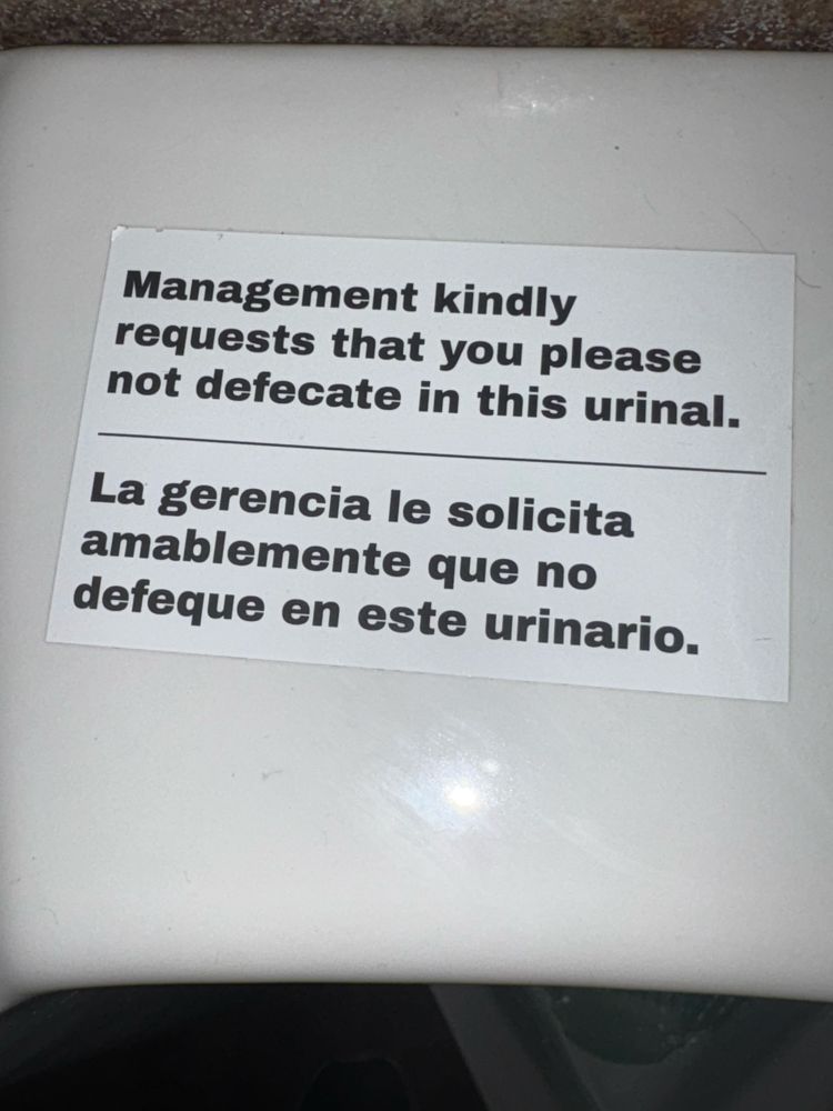 Sign that says “Management kindly requests that you please not defecate in this urinal.” 