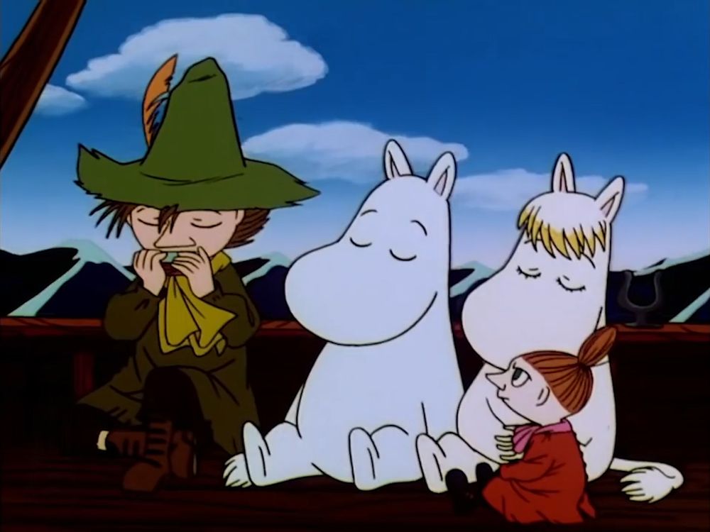 Snufkin, Moomin, Snorkmaiden and Little My are on a boat at sea. Snufkin is playing the harmonica. Moomin and Snorkmaiden have their eyes closed while Little My is looking at Snufkin. 