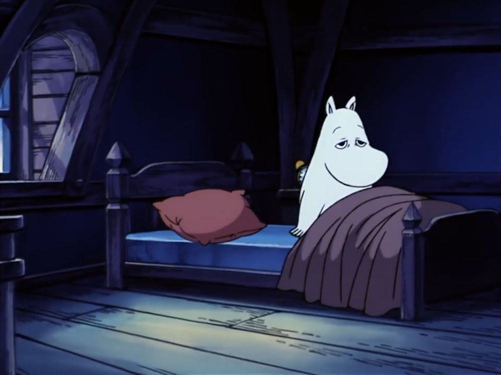 Moomin is now seated in his bed, looking very tired. 