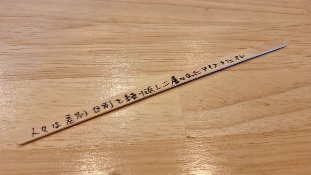 人々は差別区別を繰り返し二層になったアイスカフェオレ、と書かれた木製のマドラー