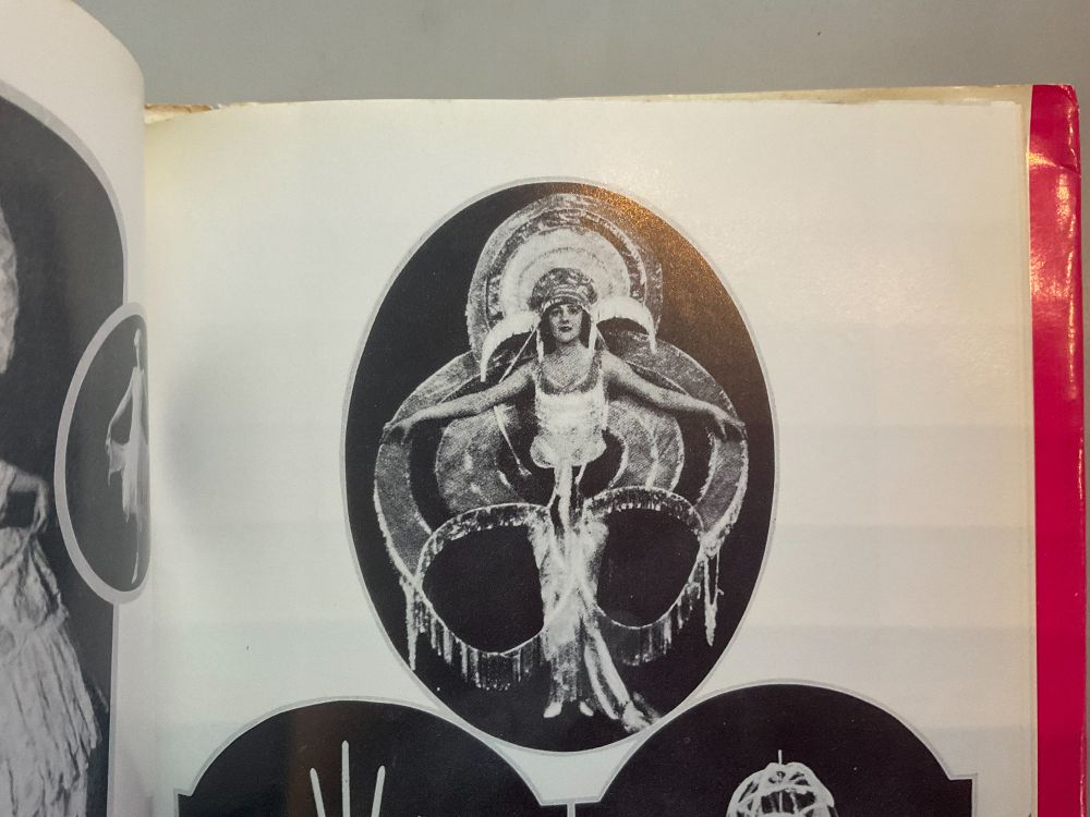 c 1900 showgirl arms outstretched in biohazard shaped regalia