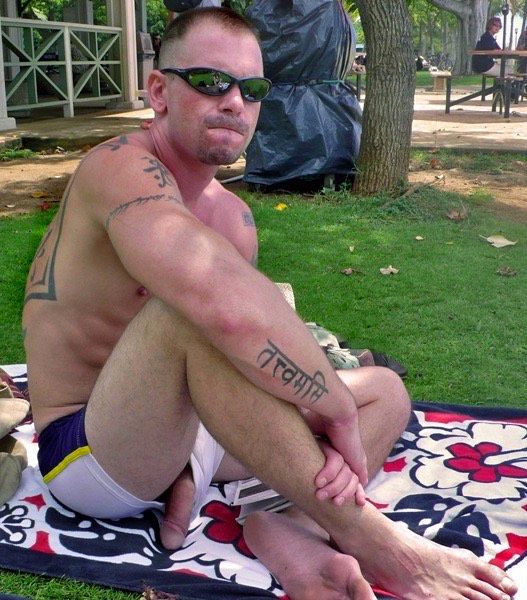 young furry inky dude on a towel in the grass chilling with his big slab of semi-tumescent meat hanging out