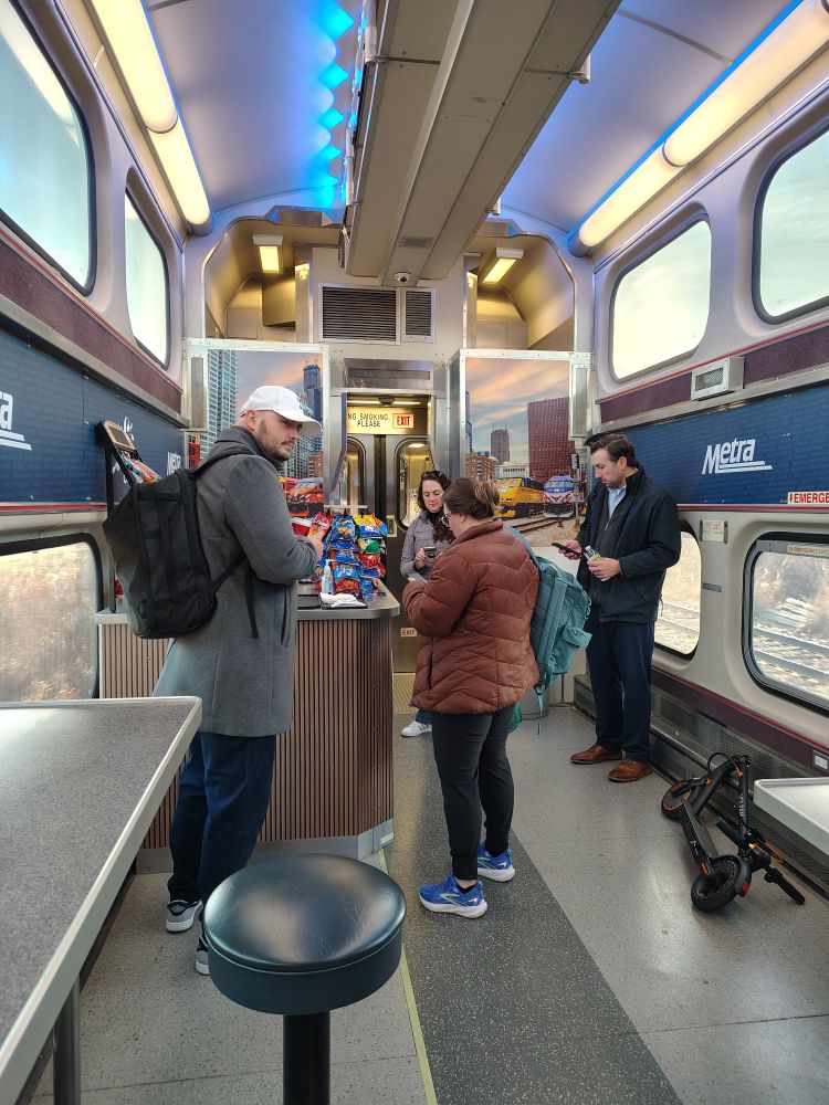Multiple people inside the Metra cafe car