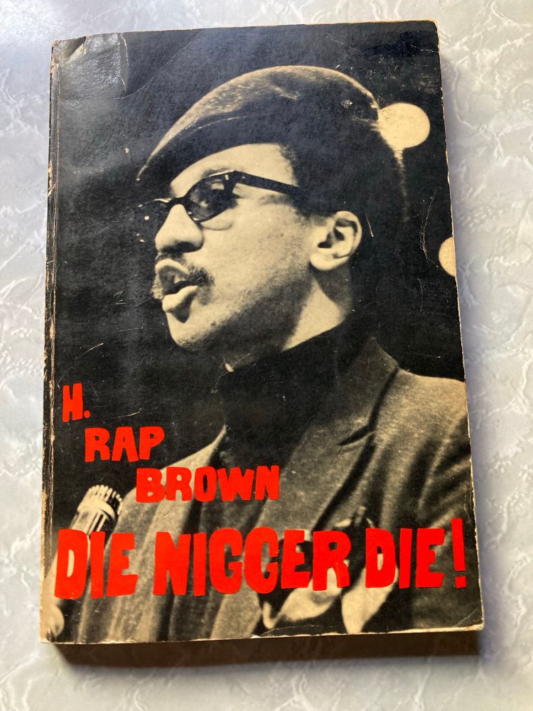 H Rap Brown, in black and white, wearing beret & sunglasses, turtle neck & jacket, on the cover of the PB edition of his memoir ‘Die, N***** Die.’ 