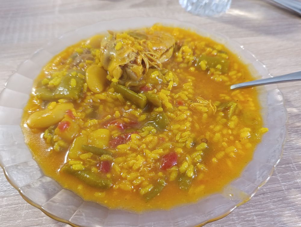 Plato de arroz caldoso con pollo, nabo, habichuelas y garrofó 