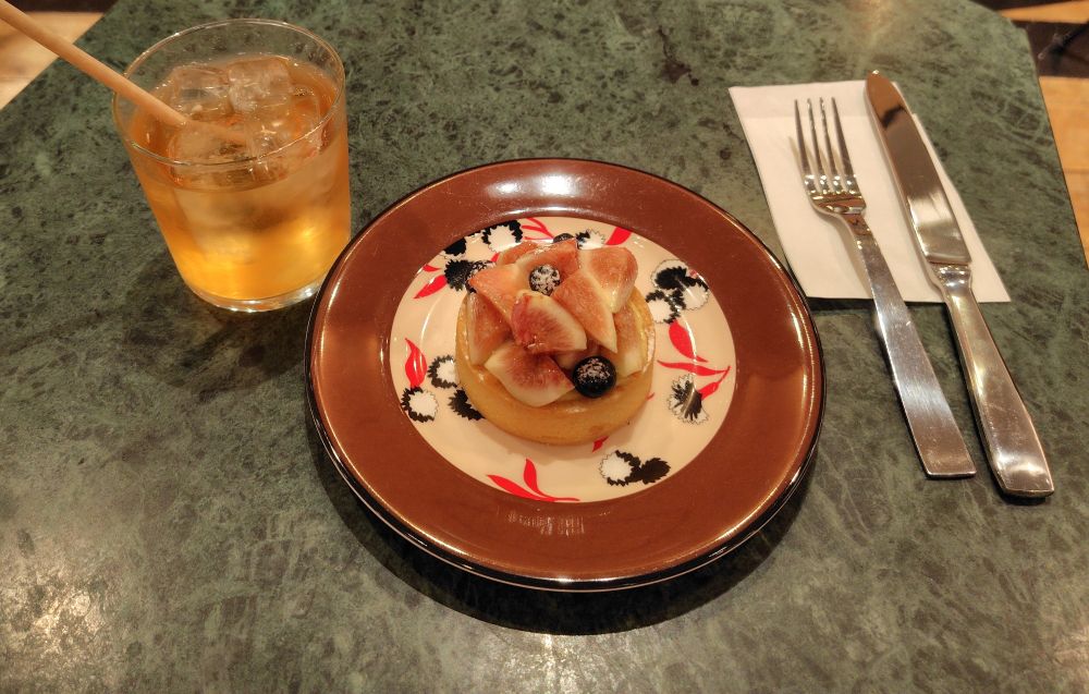 アイスのネパールティー、イチジクのタルト（小さい丸型、ブルーベリーものっている）、ナイフとフォーク。