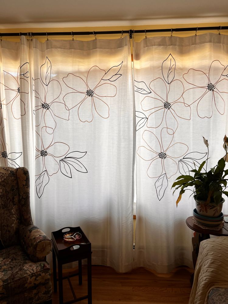 White living room curtains (both the liner curtains and long drapes) pulled closed.